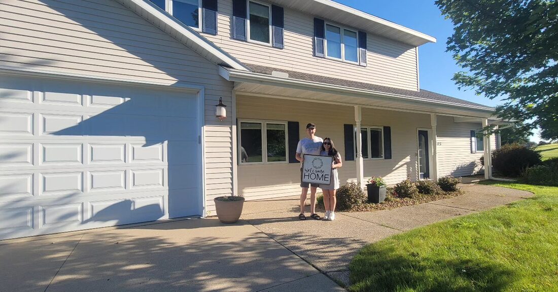 Jack and Josie outside their home in New London, Minnesota on closing day